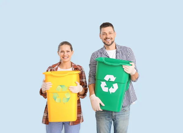 Casal com recipientes para lixo no fundo de cor. Conceito de reciclagem — Fotografia de Stock