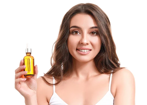 Beautiful young woman with bottle of serum on white background — Stock Photo, Image