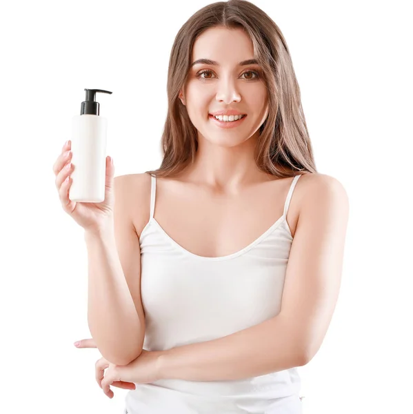 Beautiful young woman with bottle of cream on light background — Stock Photo, Image