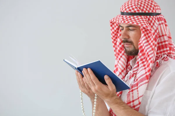 Muszlim férfi Korán és gyöngyök a könnyű háttér — Stock Fotó