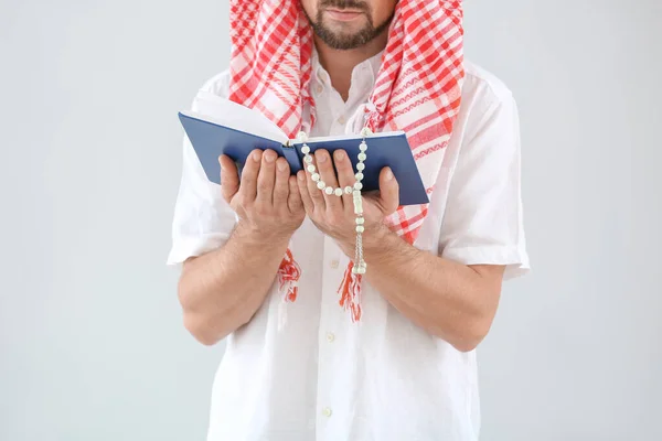 Hombre musulmán con Corán y cuentas sobre fondo claro — Foto de Stock