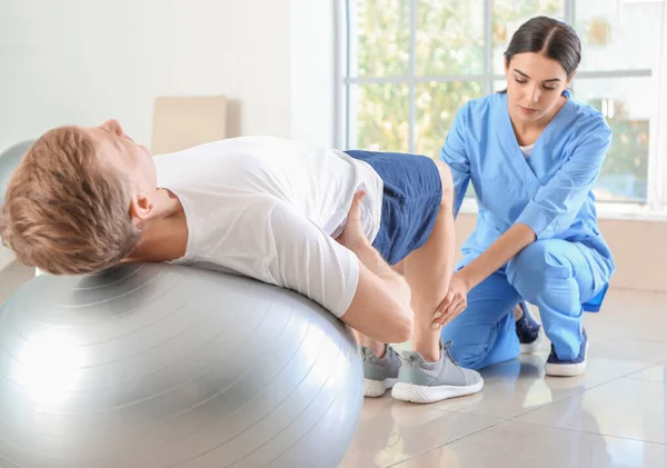 Physiotherapist working with male patient in rehabilitation center — Stock Photo, Image