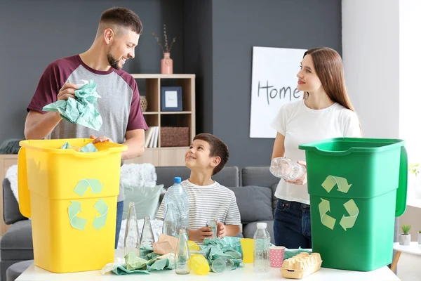 Family sorting garbage at home. Concept of recycling