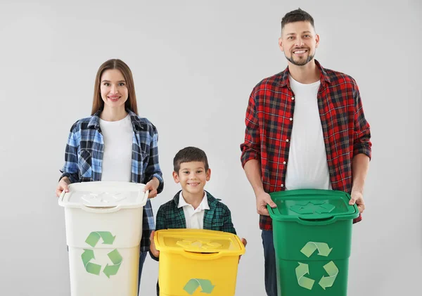Familia con contenedores para basura sobre fondo claro. Concepto de reciclaje — Foto de Stock