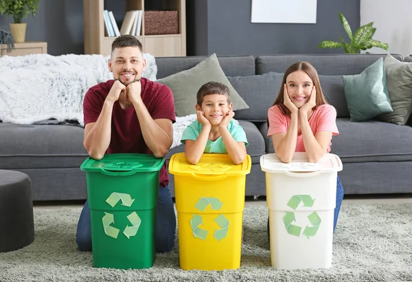 Familia con contenedores para basura en casa. Concepto de reciclaje — Foto de Stock