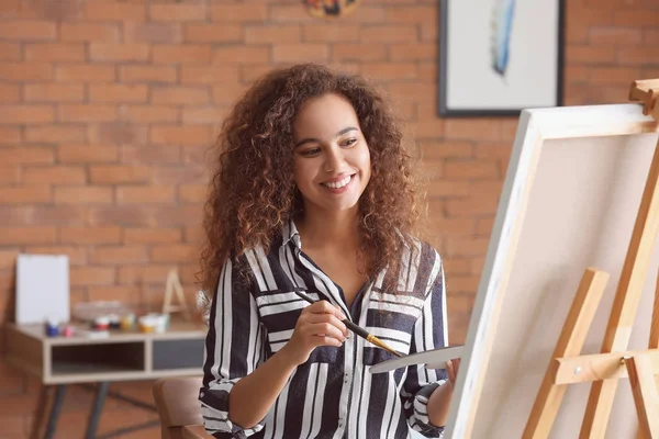 Stüdyoda güzel bir Afro-Amerikan ressam.