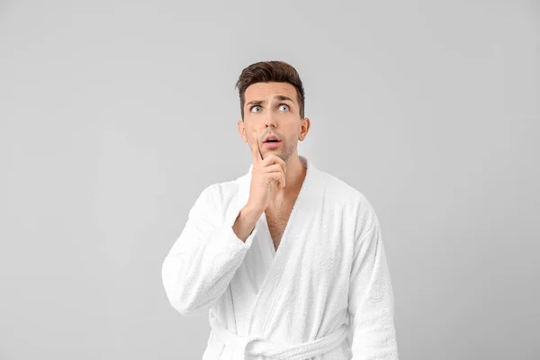 Surprised man in bathrobe on grey background — Stock Photo, Image