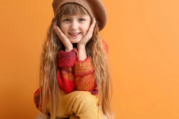 Cute little girl in autumn clothes on color background — Stock Photo, Image