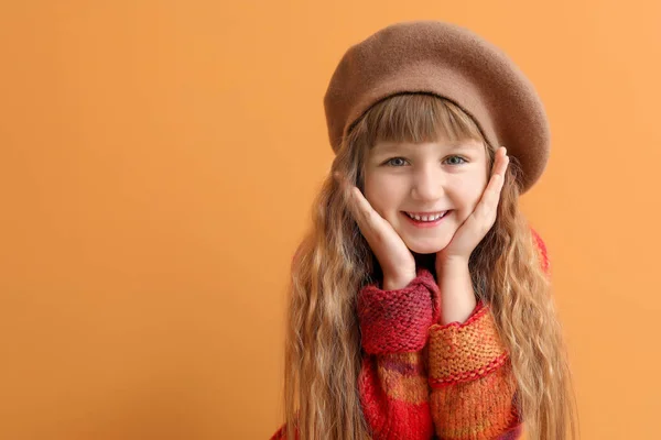 Cute little girl in autumn clothes on color background — Stock Photo, Image