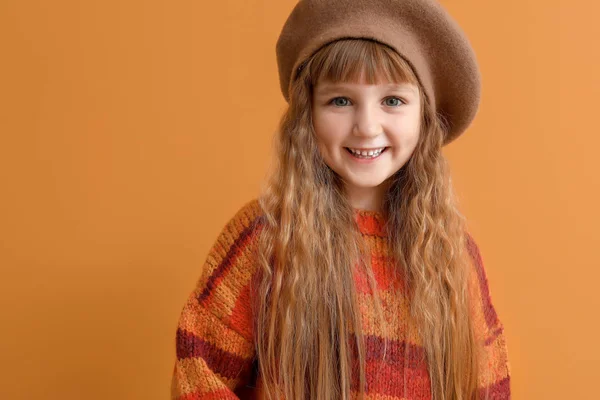 Cute little girl in autumn clothes on color background — Stock Photo, Image