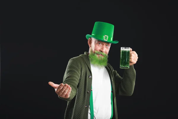Vicces, érett férfi egy pohár sörrel, aki sötét háttérrel hívogatja a nézőt. Szent Patrik napi ünnepség — Stock Fotó