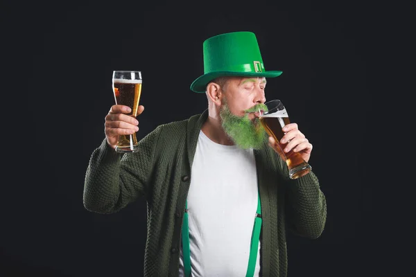 Lustiger älterer Mann mit Biergläsern auf dunklem Hintergrund. St. Patrick 's Day Feier — Stockfoto