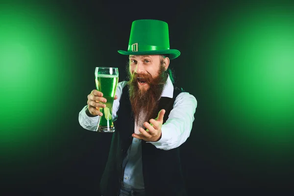 Bearded man with glass of beer inviting viewer on dark background. St. Patrick's Day celebration — Stock Photo, Image