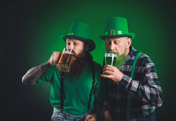 Skäggiga män med glas öl på mörk bakgrund. St. Patrick 's Day firande — Stockfoto