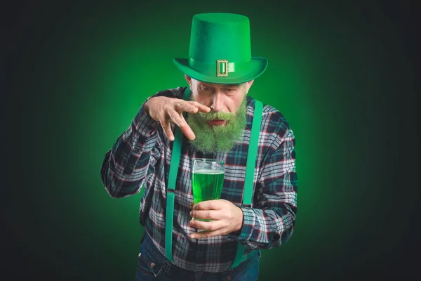 Zabawny dojrzały mężczyzna ze szklanką piwa na ciemnym tle. Święto św. Patryka — Zdjęcie stockowe