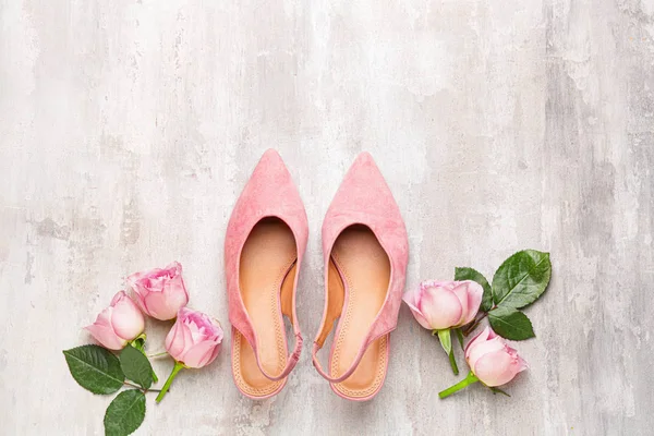 Şık kadın ayakkabıları ve açık arkaplanda çiçekler