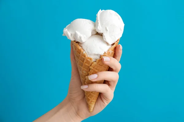 Female hand with sweet ice-cream on color background — Stock Photo, Image