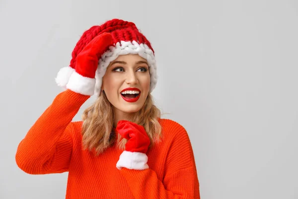 Hermosa joven en Santa sombrero sobre fondo claro — Foto de Stock