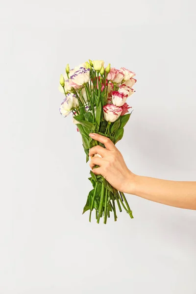 Mano de florista con hermoso ramo sobre fondo blanco — Foto de Stock