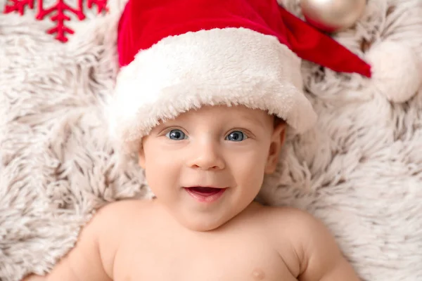가래 위에 누워 있는 산타클로스 모자를 쓴 귀여운 아기 — 스톡 사진