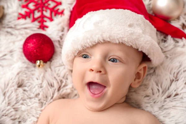 Маленьке маля в капелюсі Санта Клауса лежить на дошці. — стокове фото