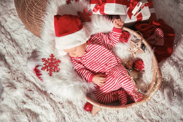 Bebé bonito com chapéu de Papai Noel dormindo em cesta, vista superior — Fotografia de Stock