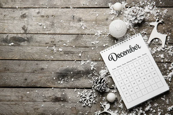 Decoración navideña, nieve y calendario sobre fondo de madera — Foto de Stock