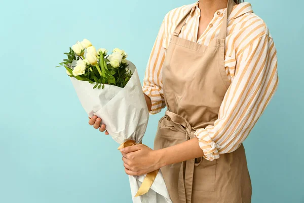 Female florist with beautiful bouquet on color background — Stock Photo, Image