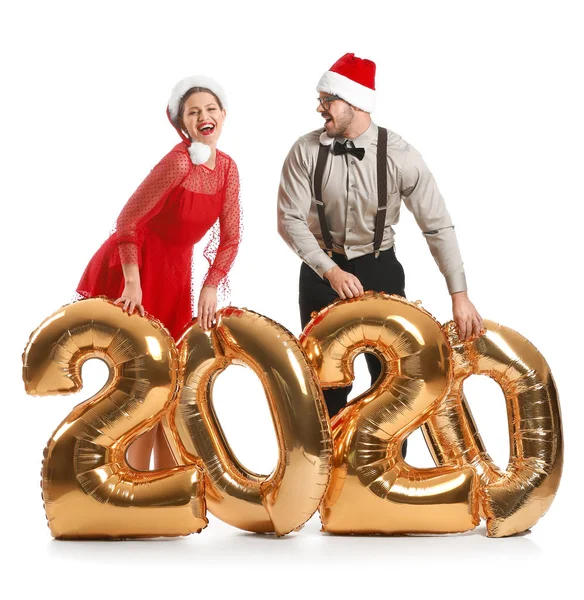 Glada par i Santa Claus hattar och med luftballonger på vit bakgrund — Stockfoto