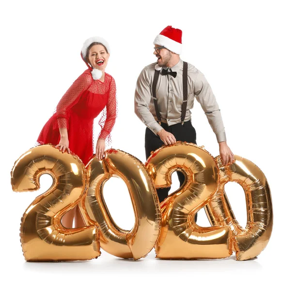 Happy couple in Santa Claus hats and with air balloons on white background — Stock Photo, Image