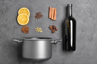 Gri arka planda lezzetli sıcak şarap için demlik ve malzemeler