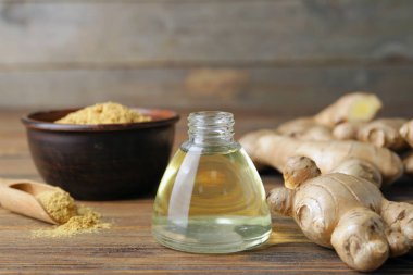 Ahşap masada zencefil esanslı yağ şişesi