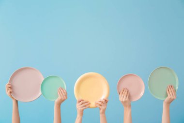 Renk arkaplanında farklı temiz plakalara sahip eller