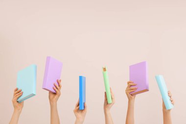 Renk arkaplanı üzerine kitapları olan kadın elleri