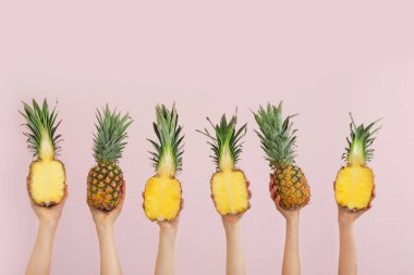 Renkli arka planda sulu ananaslı eller
