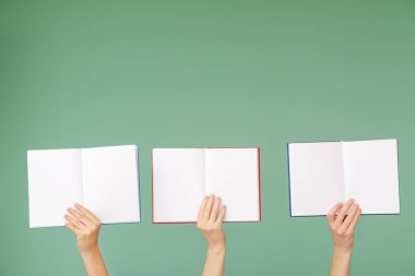 Renk arkaplanı üzerine kitapları olan kadın elleri