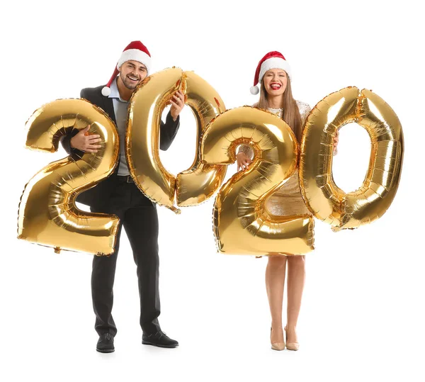 Gelukkig paar in Santa Claus hoeden en met luchtballonnen op witte achtergrond — Stockfoto