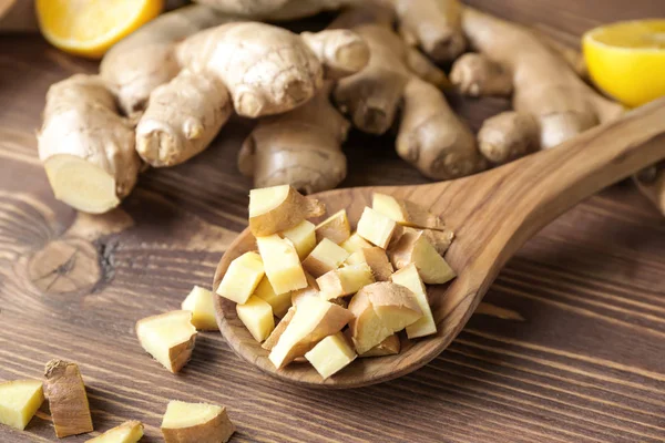 Spoon with fresh ginger on wooden table — Stock Photo, Image