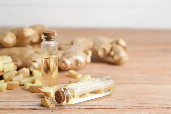 Бутылки с имбирным эфирным маслом на деревянном столе — стоковое фото