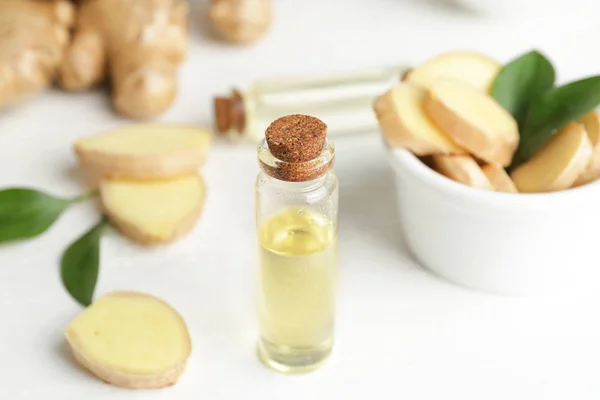 Bottle with ginger essential oil on white table — Stock Photo, Image