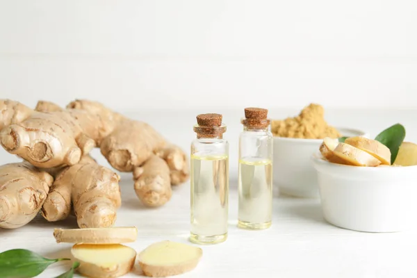 Bottles with ginger essential oil on wooden table — Stock Photo, Image