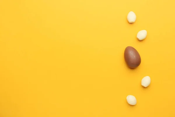 Brown chocolate Easter egg among white ones on color background. Concept of uniqueness — Stock Photo, Image