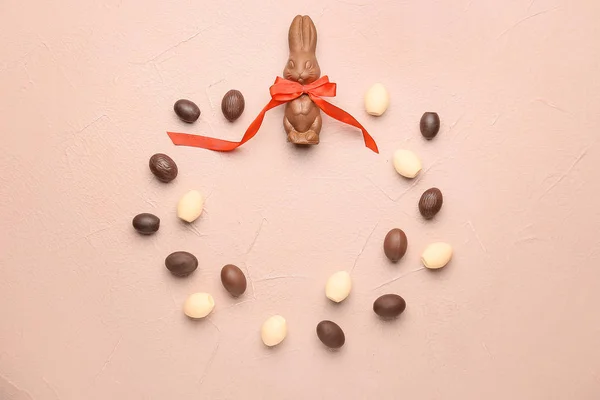 Frame made of chocolate Easter eggs and bunny on color background — Stock Photo, Image