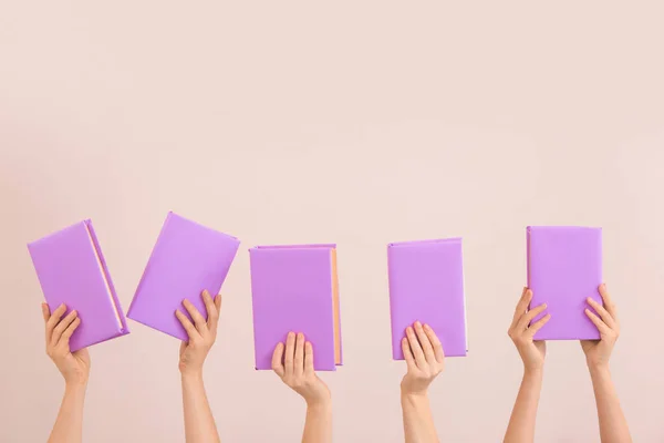 Vrouwelijke handen met boeken over kleur achtergrond — Stockfoto