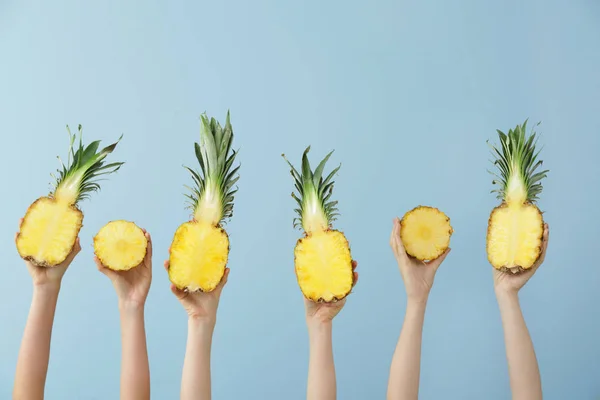 Hands with juicy pineapples on color background — Stock Photo, Image