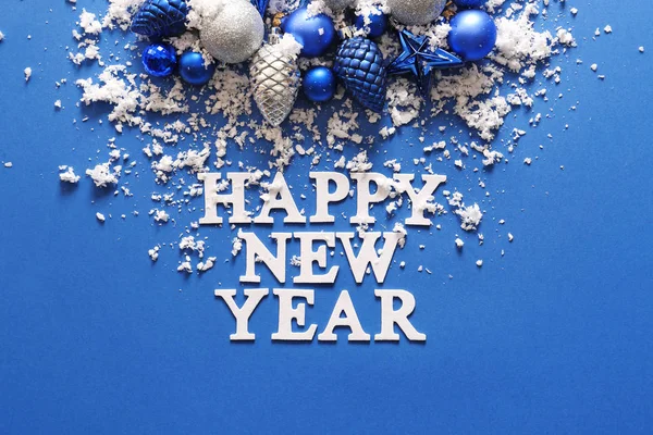Texte HAPPY NEW YEAR avec décor et neige sur fond de couleur — Photo