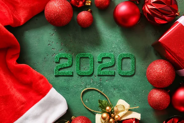 Figura 2020 con sombrero y decoración de Santa Claus sobre fondo de color — Foto de Stock