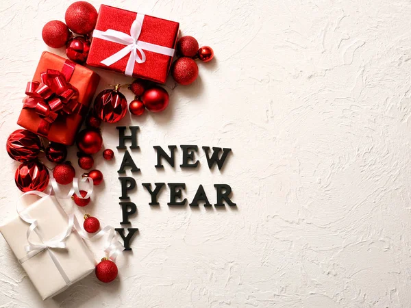Text HAPPY NEW YEAR with decor and gifts on white background — Stock Photo, Image