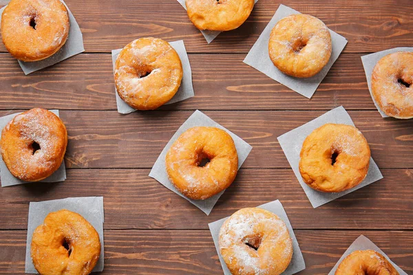 Doce saboroso donuts no fundo de madeira — Fotografia de Stock