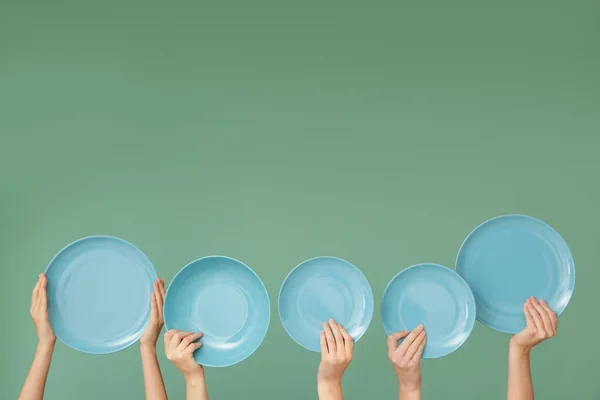 Hände mit sauberen Platten auf farbigem Hintergrund — Stockfoto
